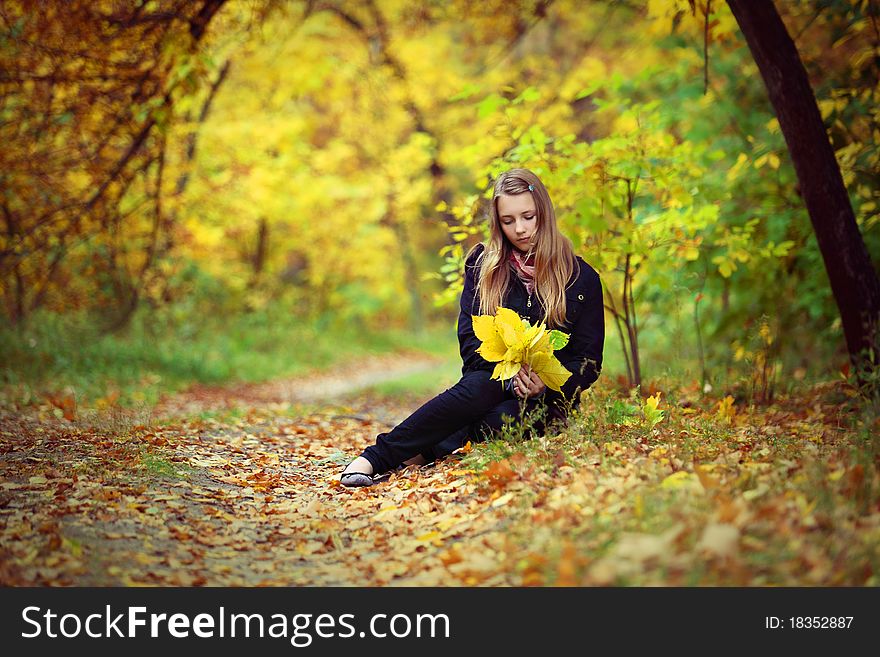 A beautiful girl goes for a walk in an autumn park. A beautiful girl goes for a walk in an autumn park