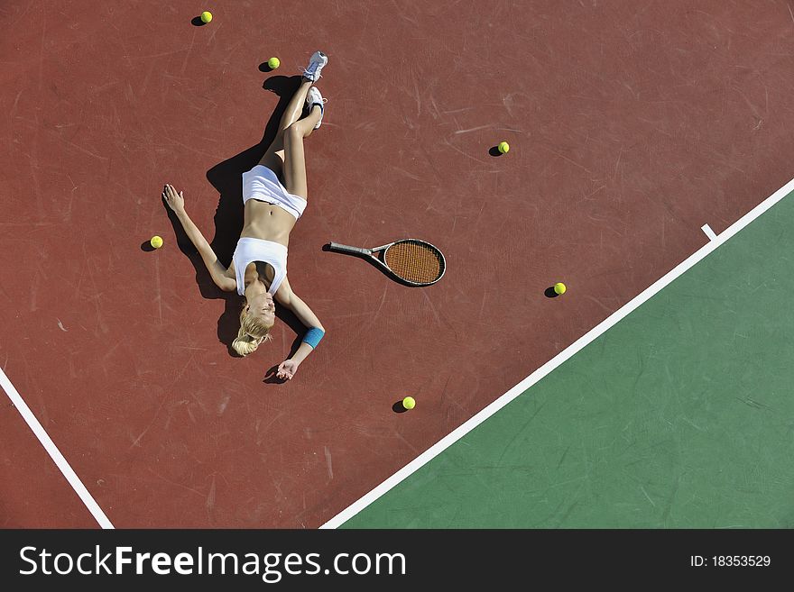 Young fit woman play tennis outdoor on orange tennis field at early morning. Young fit woman play tennis outdoor on orange tennis field at early morning