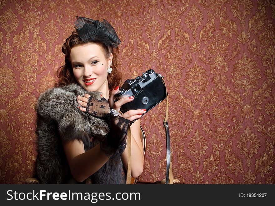 Young vintage woman with camera in old-style studio. Young vintage woman with camera in old-style studio