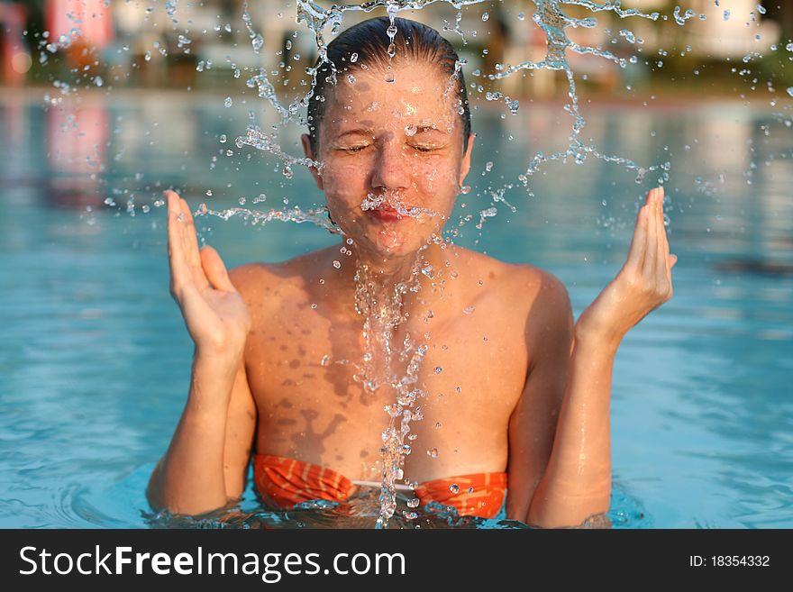 Woman in swimming pool play with water splash