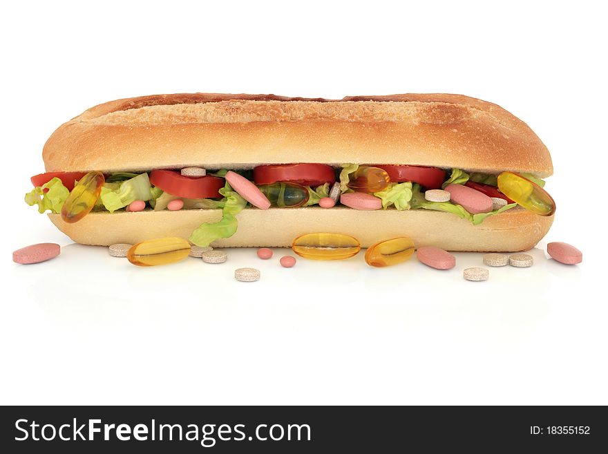 Vitamin pill selection scattered and in a cucumber, tomato and lettuce french roll, over white background. Vitamin pill selection scattered and in a cucumber, tomato and lettuce french roll, over white background.