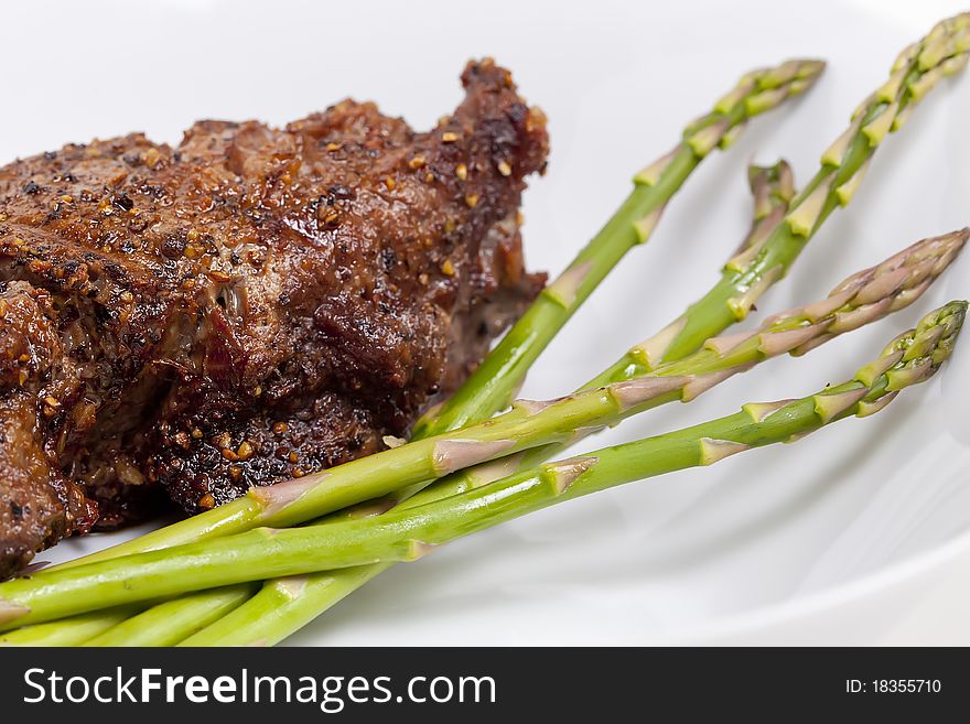 A prime Fillet Mignon grilled to perfection au poive with peppercorns and garnished with fresh asparagus. A prime Fillet Mignon grilled to perfection au poive with peppercorns and garnished with fresh asparagus.
