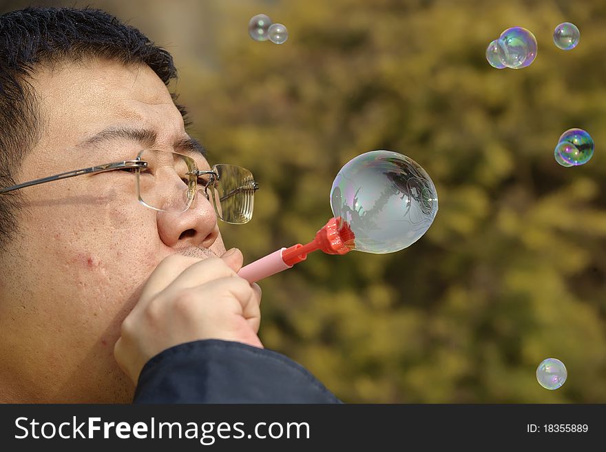 A Man Blowing Soap Bubbles