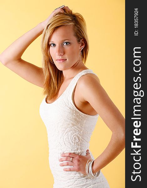 Young woman poses wearing white cocktail dress. Young woman poses wearing white cocktail dress.