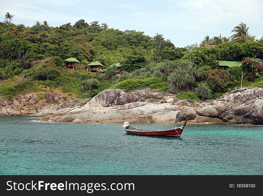 Longtail boat near island, in blue water. Longtail boat near island, in blue water