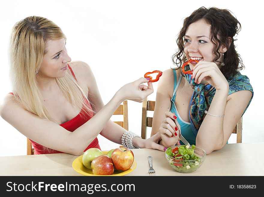 Girlfriends cheerfully feed each other with healthy food