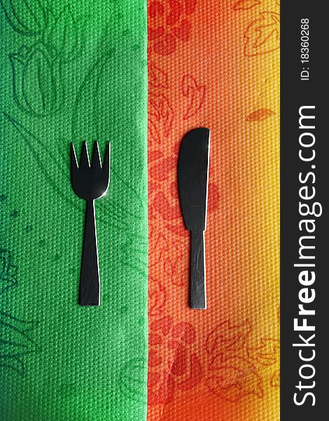 Old knife and fork on colorful tablecloth. Old knife and fork on colorful tablecloth