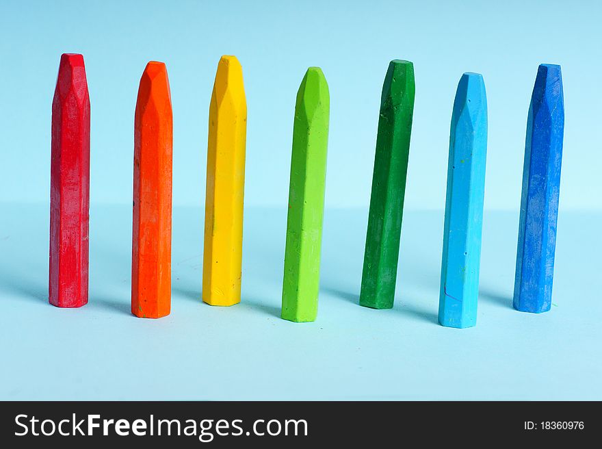 Colorful crayons on the blue background
