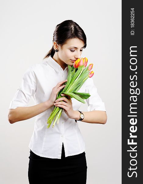 An image of young woman holding a bunch of orange tulips. An image of young woman holding a bunch of orange tulips