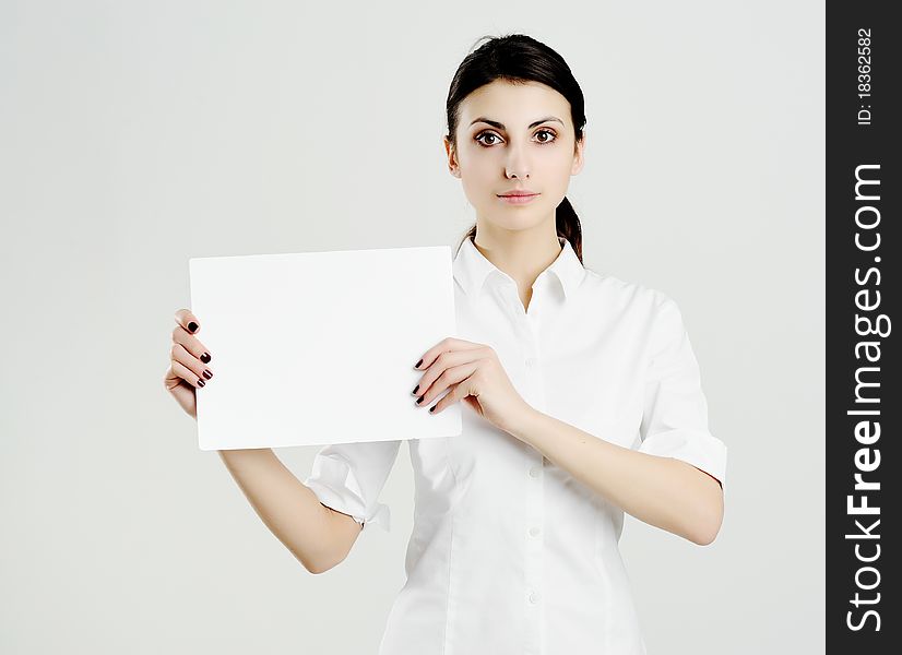 An image of young woman holding white paper. An image of young woman holding white paper