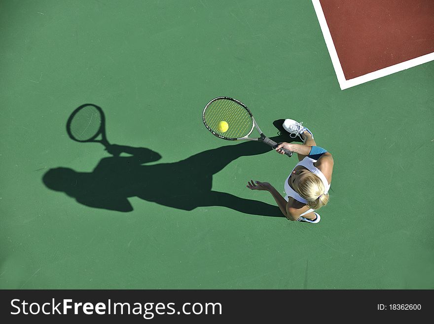 Young fit woman play tennis outdoor on orange tennis field at early morning. Young fit woman play tennis outdoor on orange tennis field at early morning