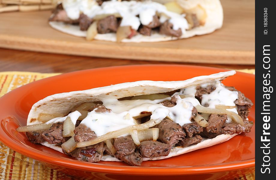 Beef pita with onions and sauce on a plate