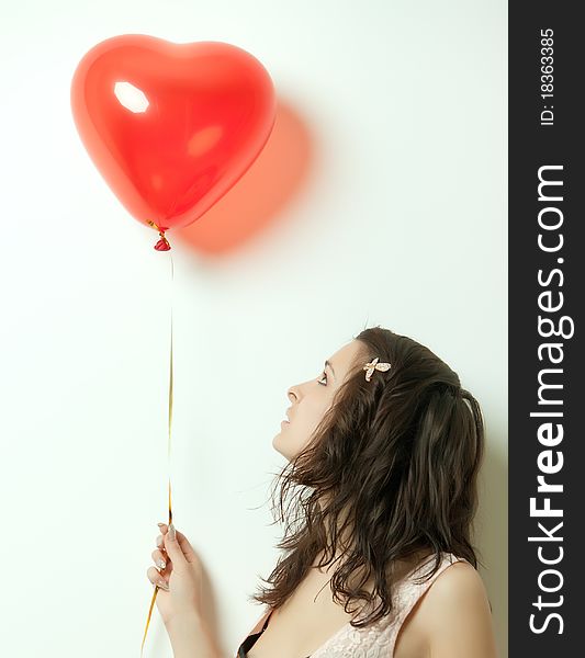 Photo of a young woman , holding red inflatable Valentines Day heart. Photo of a young woman , holding red inflatable Valentines Day heart.
