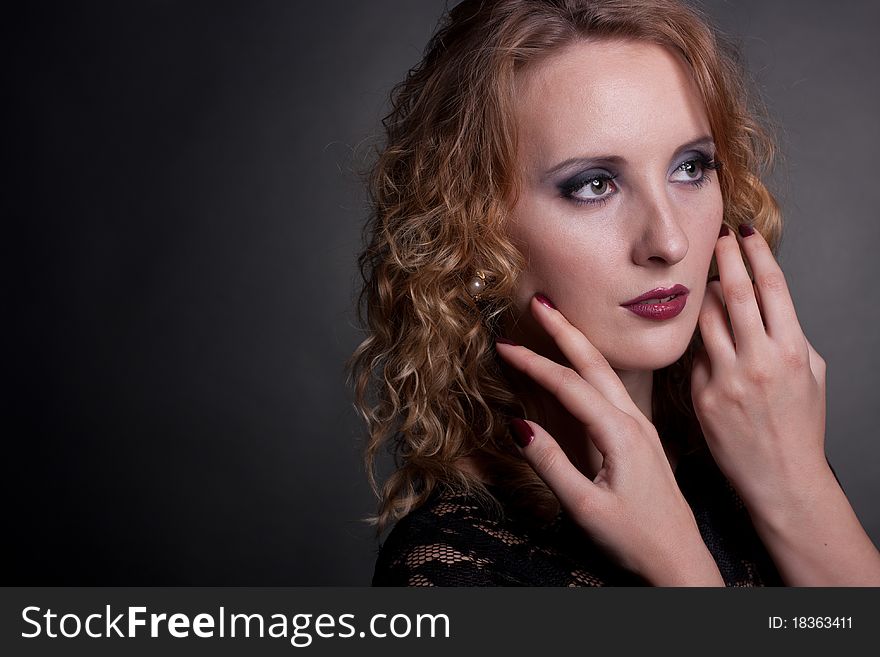 Portrait of a beautiful woman with hands near face