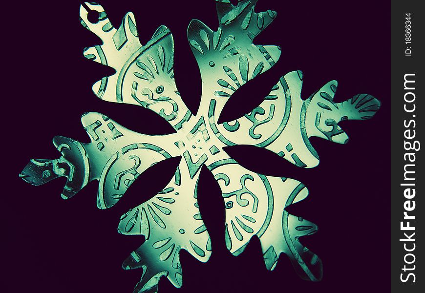 A snowflake ornament reflecting blue light. A snowflake ornament reflecting blue light.