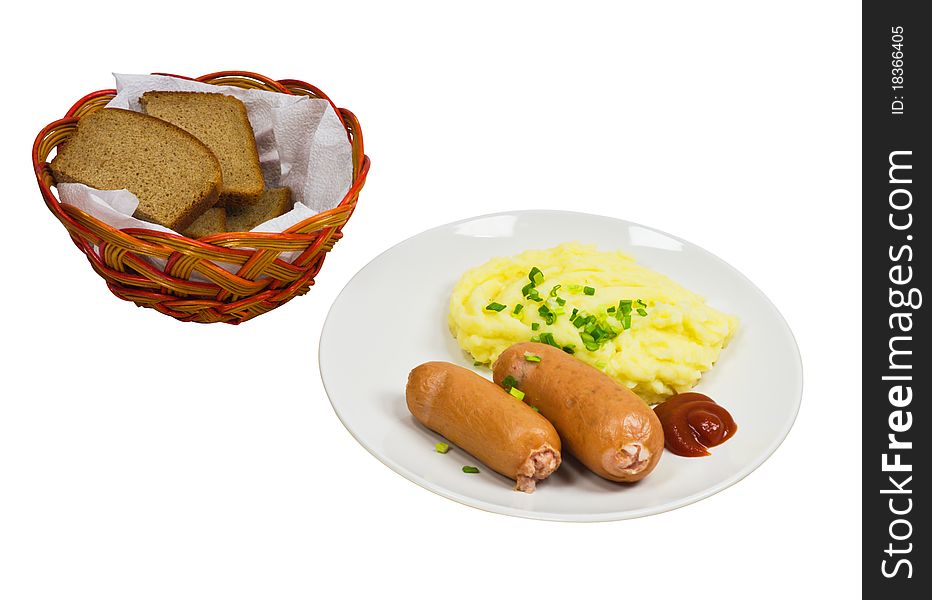 Two sausages with mashed potatoes on a plate and bread in a basket isolated on a white background
