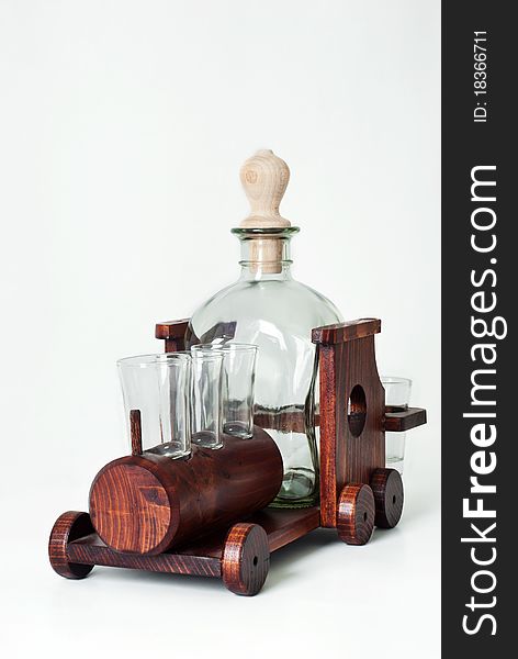 Bottle and glasses on a train wooden support isolated on a white background. Bottle and glasses on a train wooden support isolated on a white background