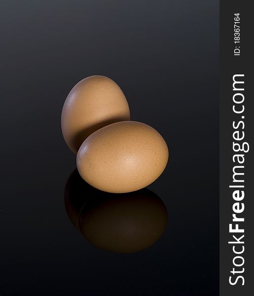 Close-up of two eggs on dark background with reflection. Close-up of two eggs on dark background with reflection