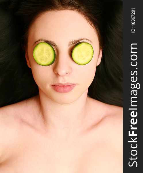 Beautiful young woman with a mask of cucumber on your face. Beautiful young woman with a mask of cucumber on your face