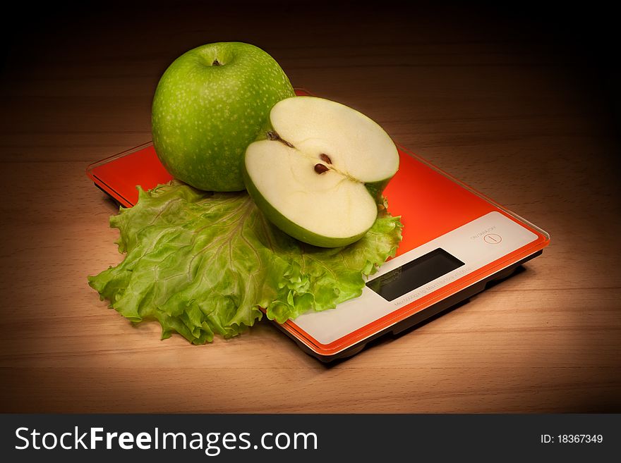 Whole and sliced apples on the scales. Whole and sliced apples on the scales.