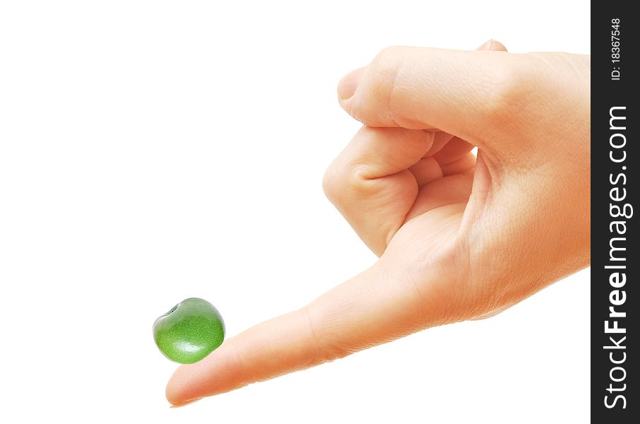 Female hand balancing a fresh small green apple on finger, on white