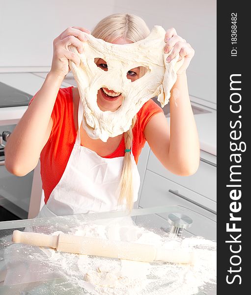 Beautiful young blond woman baking in the kitchen at home