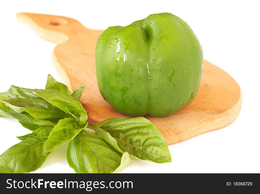 Fresh green pepper and basil on wooden board isolated on white background