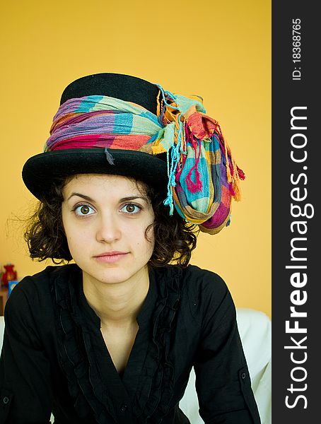 Portrait of a young woman with a black hat and a colorful scarf