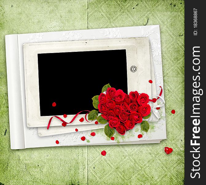 White album with red roses heart on the green