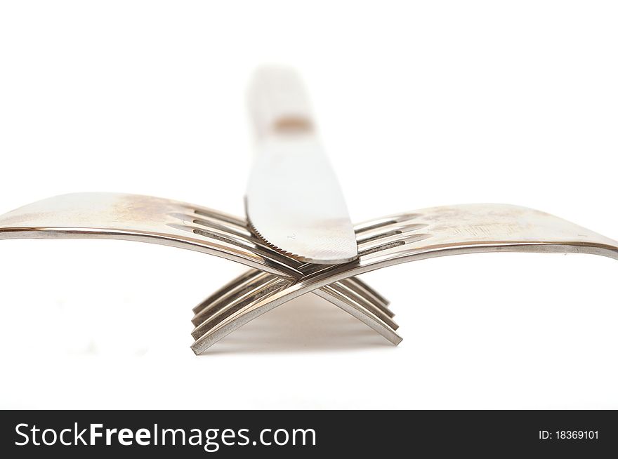 Closeup abstract of a silver knife and fork on a white background with space for text