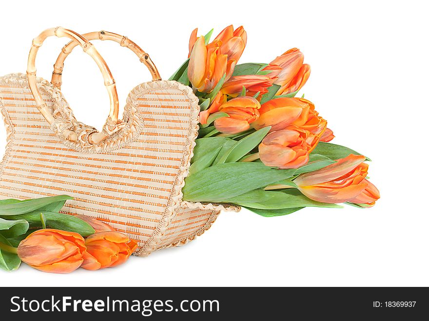 Tulips in the wicker handbag on a white background