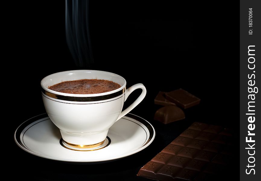 A cup of luxury chocolate drink & chocolate bar, on black background. A cup of luxury chocolate drink & chocolate bar, on black background