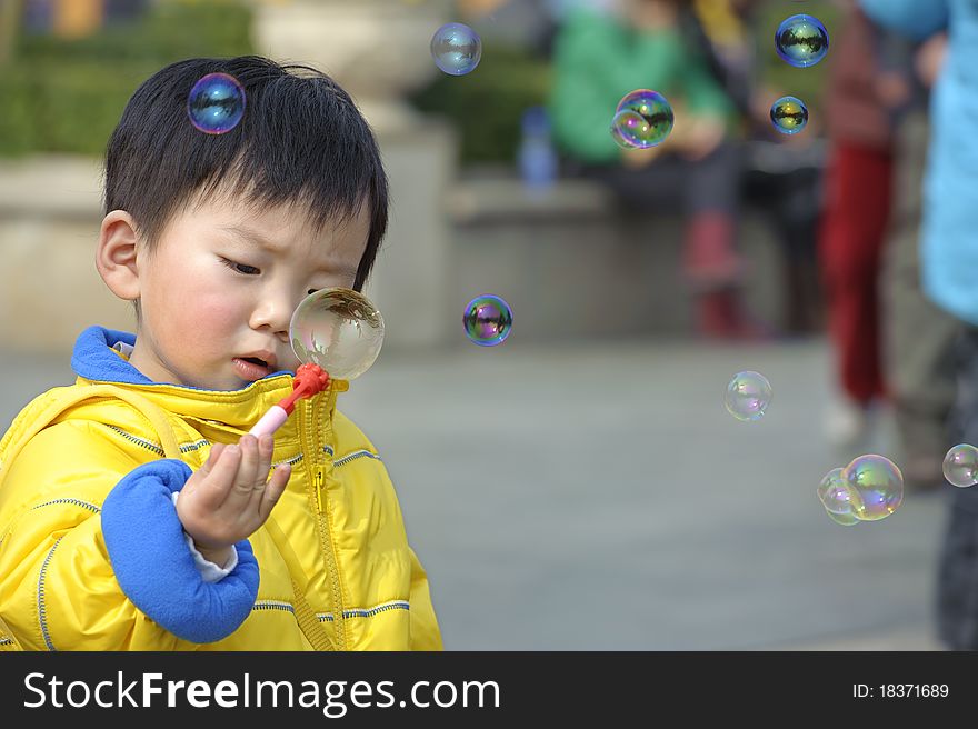 A cute child blowing soap bubbles. A cute child blowing soap bubbles