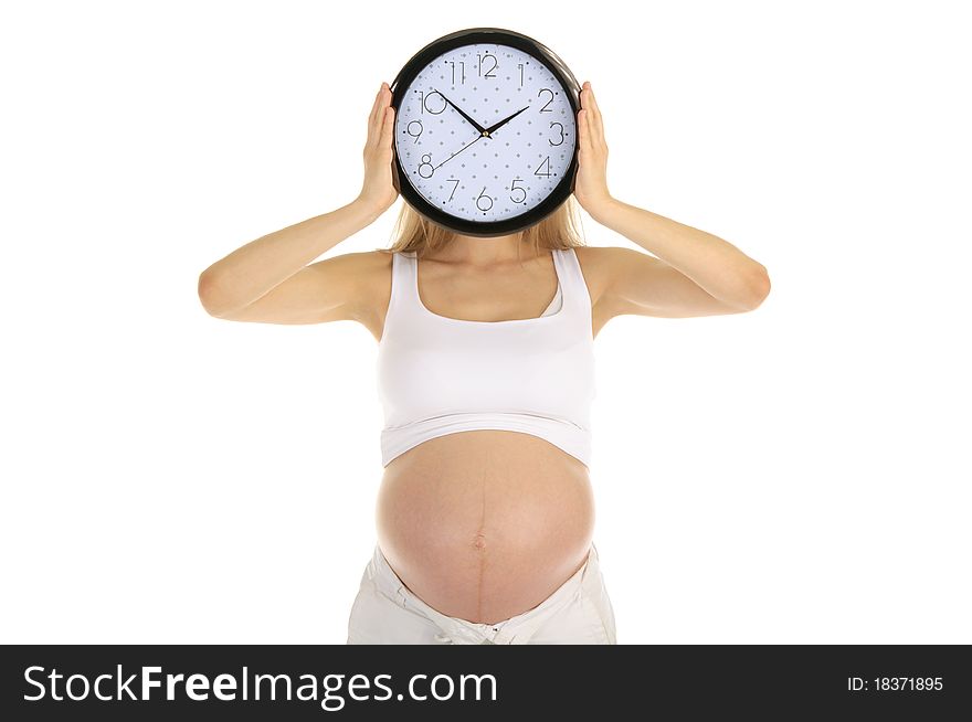 Pregnant woman holds the round clock face isolated on white