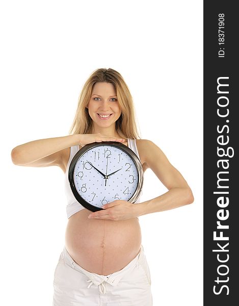 Happy pregnant woman with a round clock isolated on white