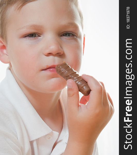 Portrait of a young boy eating chocolate bar,. Portrait of a young boy eating chocolate bar,