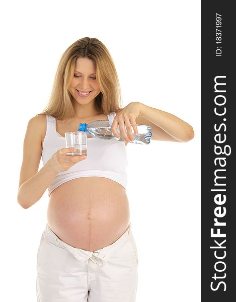 Pregnant woman pours water into a glass isolated on white