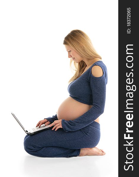 Pregnant woman with a laptop sitting on the floor isolated on white