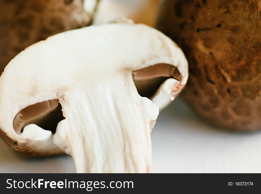 Raw mushrooms (champignons) on a white table. Raw mushrooms (champignons) on a white table