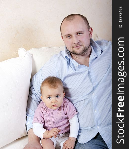 Young father with his daughter on couch