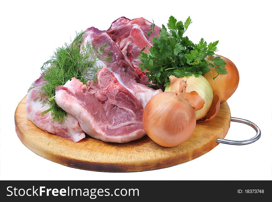 Crude pork steaks, greens of parsley, fennel and three onions it is isolated on the white. Crude pork steaks, greens of parsley, fennel and three onions it is isolated on the white..