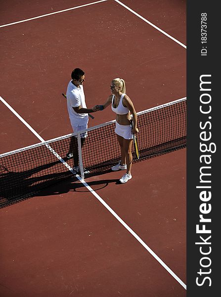 Happy young couple play tennis game outdoor men and women