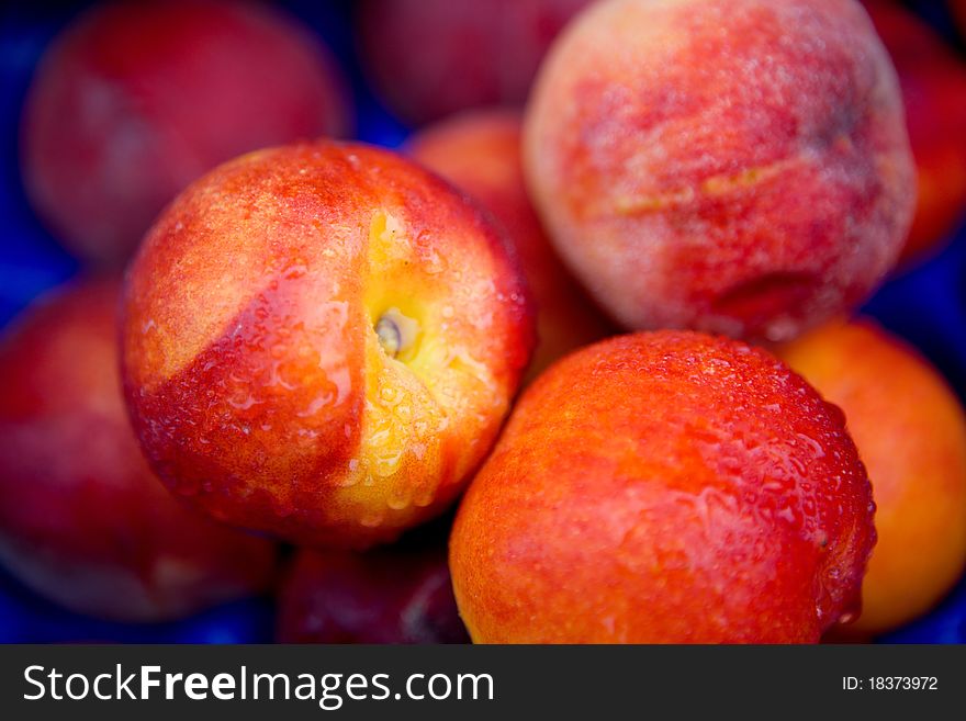 Fresh peaches in a store window with water droplets