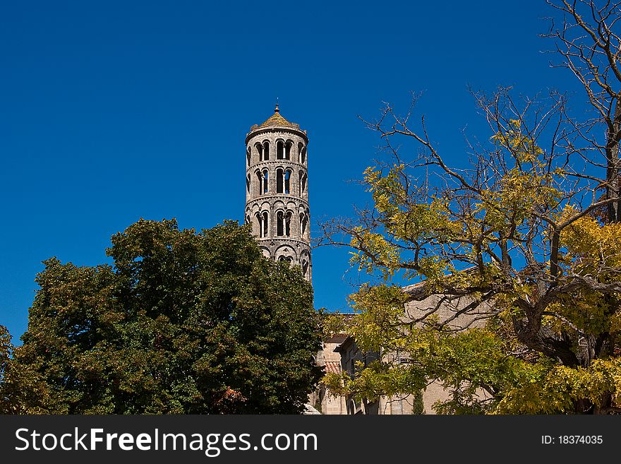 An high cylindrical bell tower rises in the blue sky