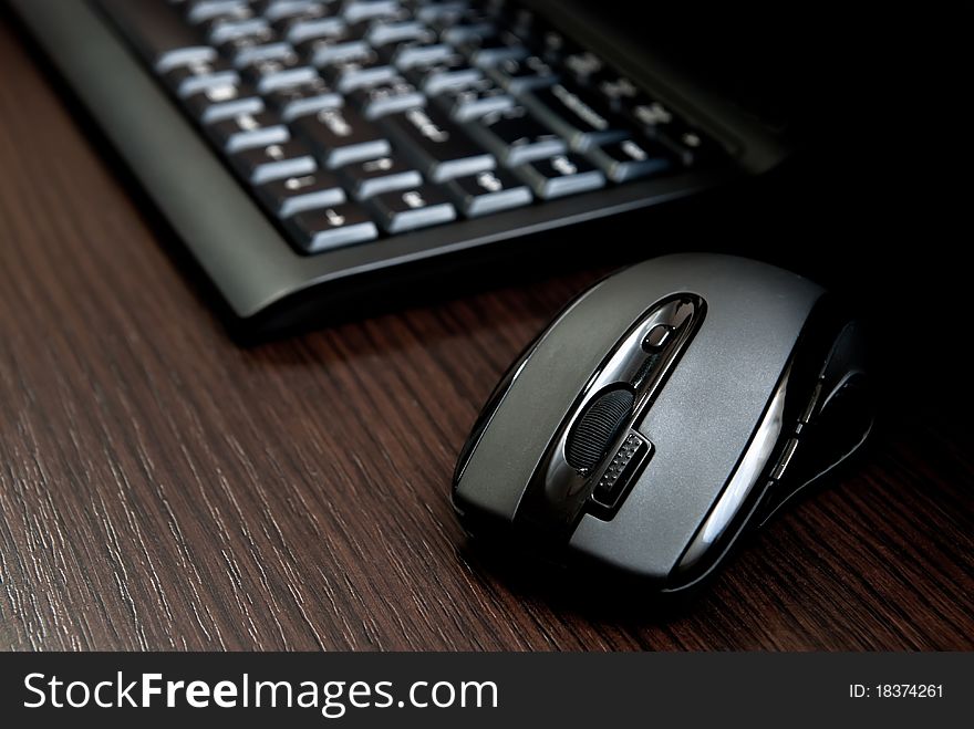 Black keyboard and mouse on a dark desk. Black keyboard and mouse on a dark desk.