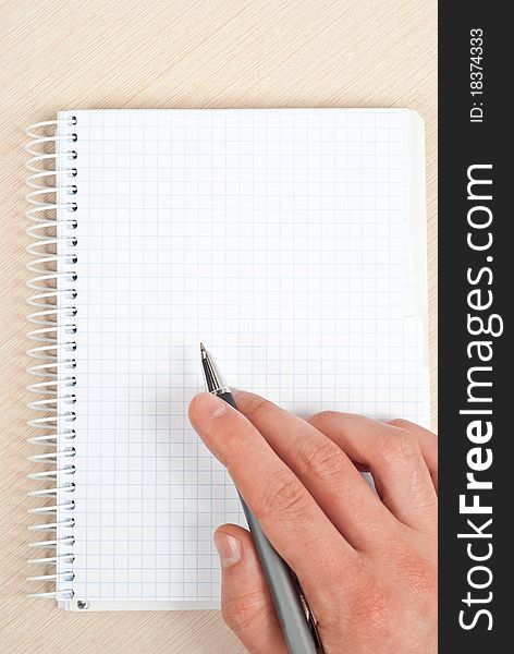 Male hand holding a pen writing notes in a notebook. Male hand holding a pen writing notes in a notebook.