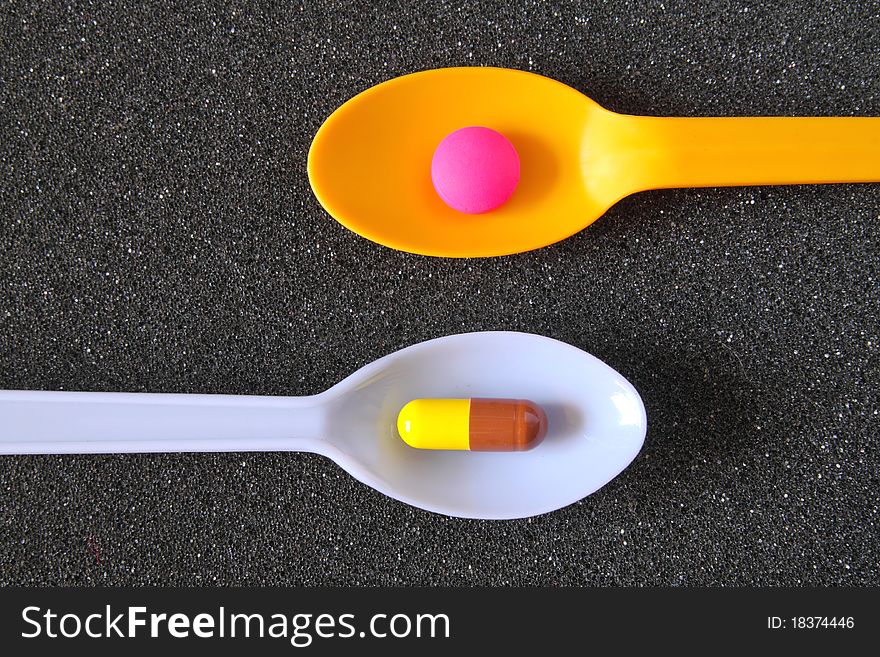Spoonful Of Pills On Black Textile
