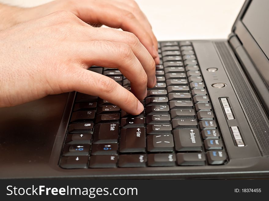Male hands typing on a laptop keyboard. Male hands typing on a laptop keyboard