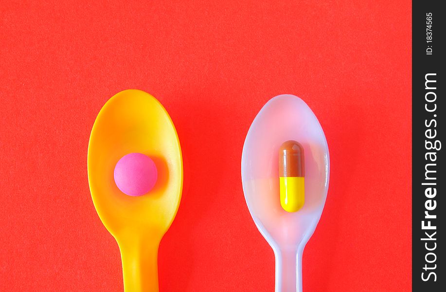 Spoonful of Pills to Keep Healthy Concept Image on red background. Spoonful of Pills to Keep Healthy Concept Image on red background