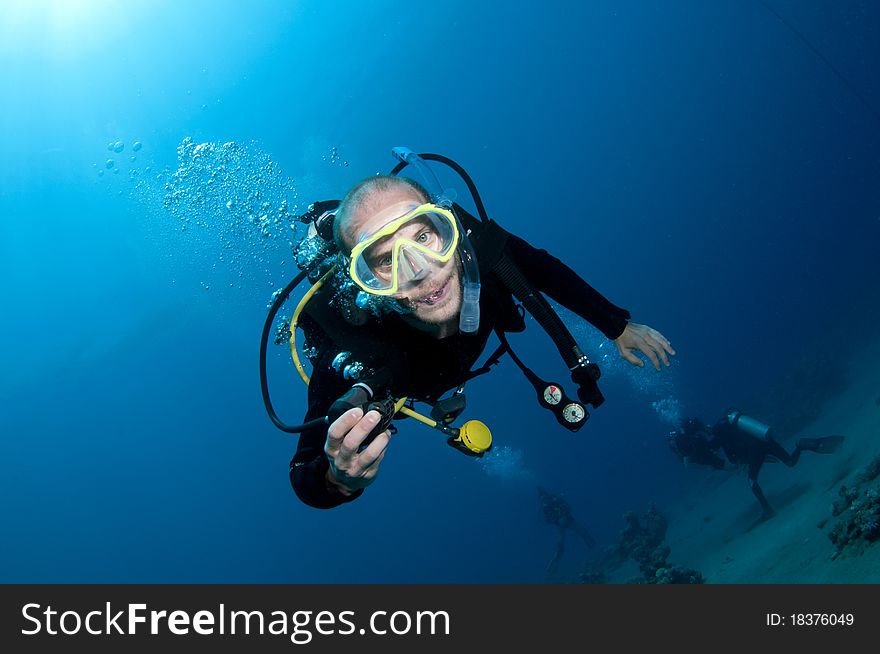 Scuba diver swim in ocean and 
takes his mouth piece out and smiles. Scuba diver swim in ocean and 
takes his mouth piece out and smiles